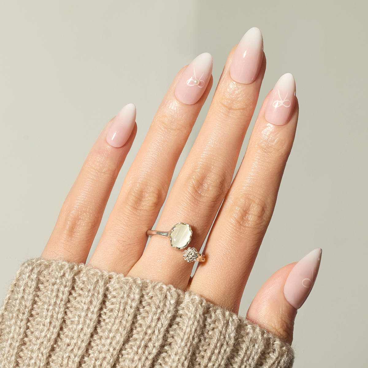 Hand wearing a ring with a beige background