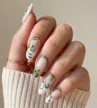 Hand with decorative nail art holding a beige sleeve against a neutral background