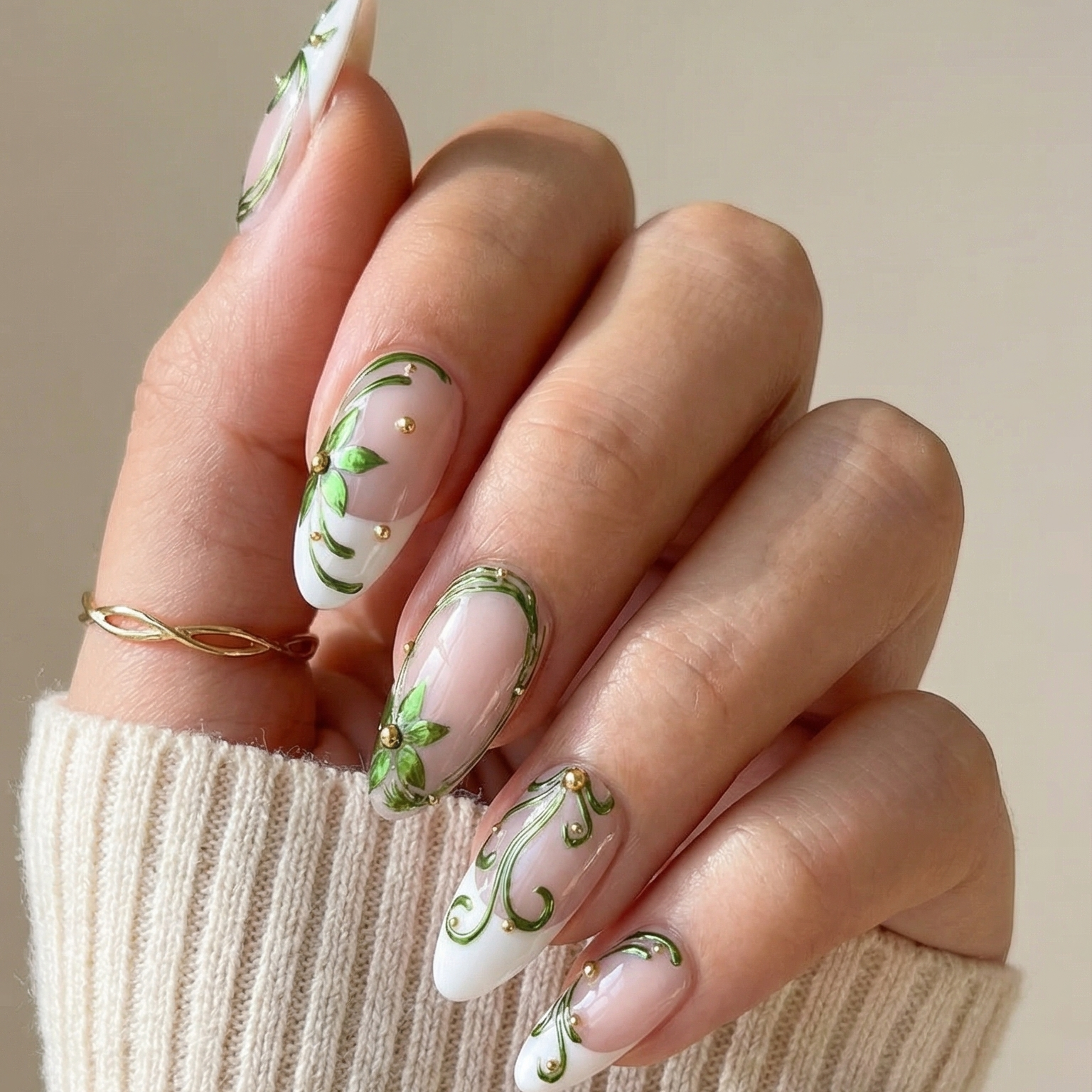 Hand with decorative nail art holding a beige sleeve against a neutral background