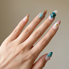 Hand with teal and white nail polish on a neutral background