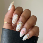 Hand with decorative nail art holding a black leather sleeve.