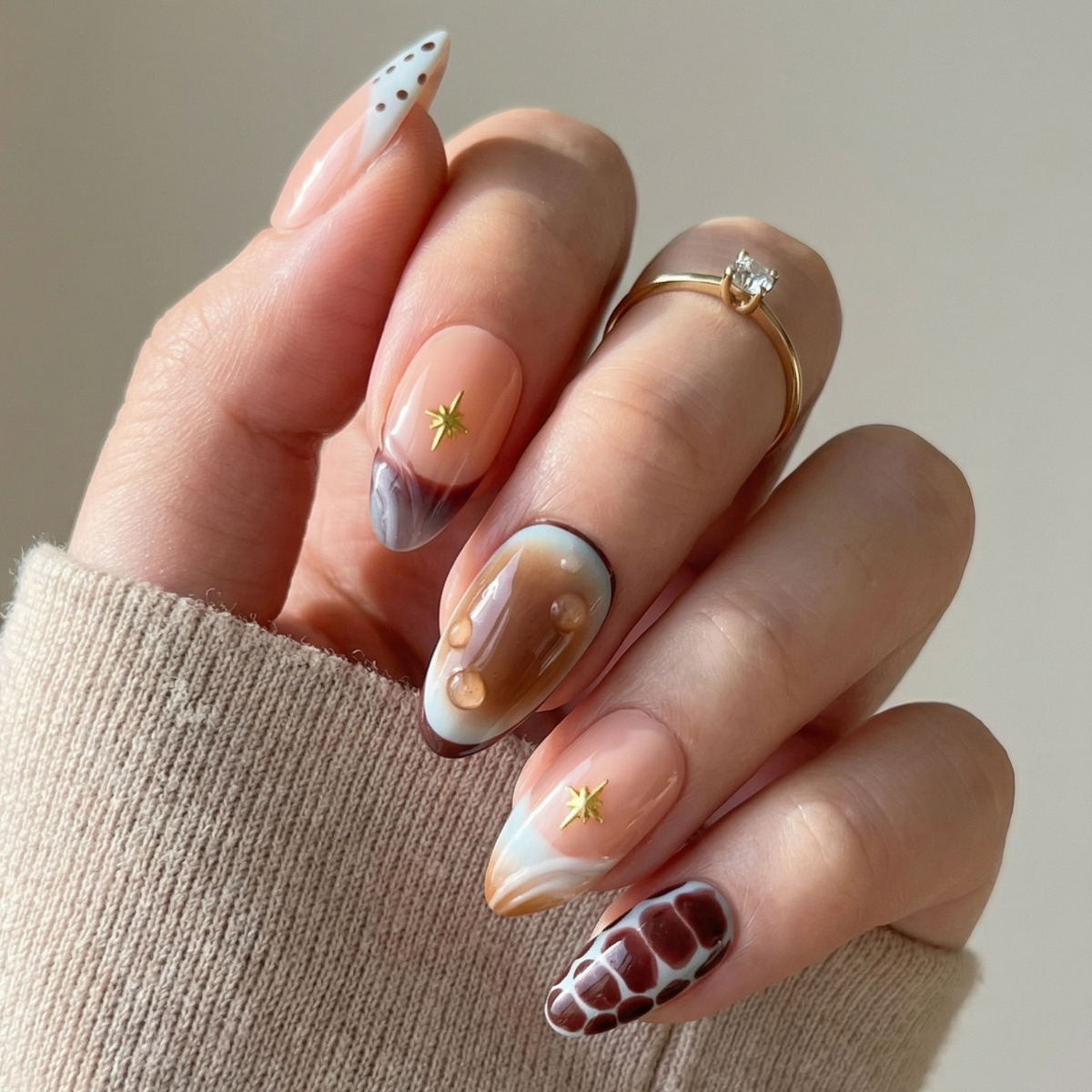 Hand with detailed nail art holding a beige sleeve against a neutral background